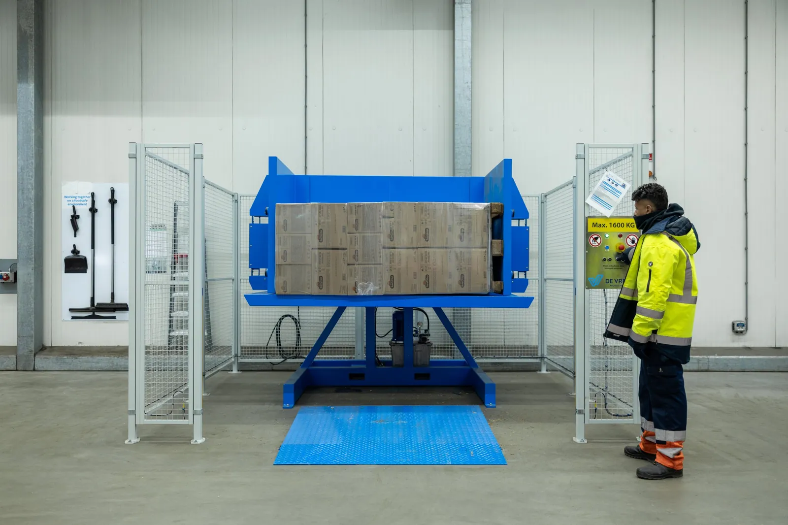 Palettenwender PalletRotator EPT mit gekippter Palette und Bediener am Bedienfeld